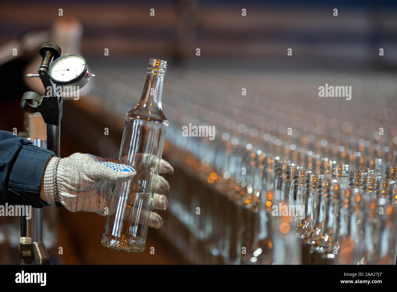 Glassworks. Glass industry. Working hands hold a glass bottle on the