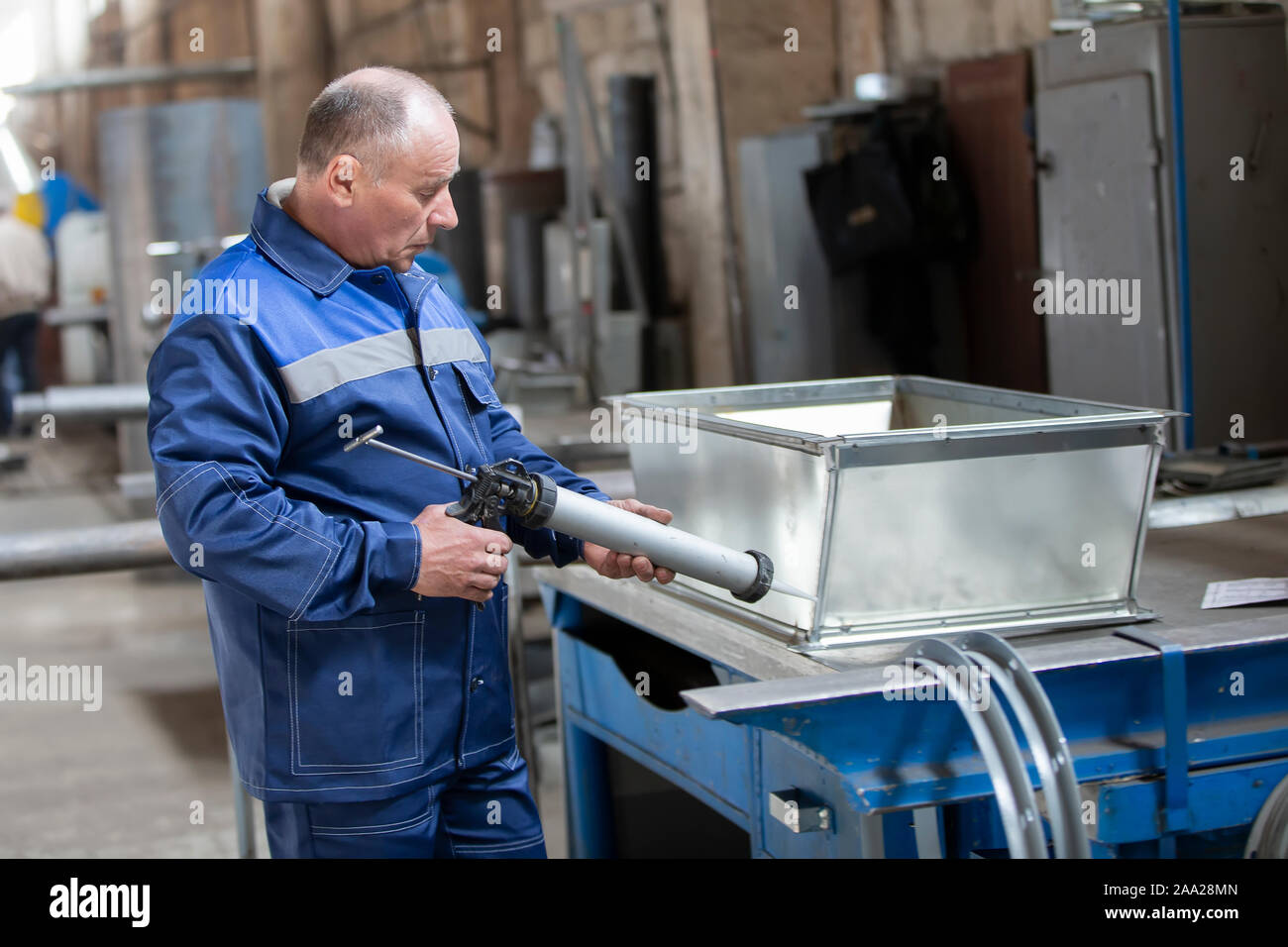 Belarus, Gomel, 25 April 2018. Factory for the manufacture of ventilation pipes.The worker at the factory makes ventilating metal pipes Stock Photo