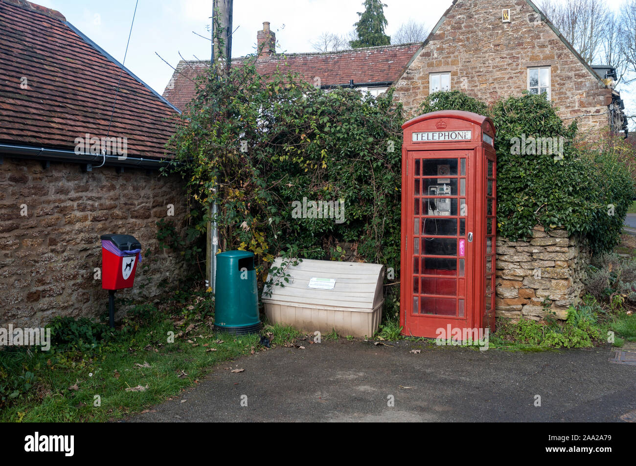 A view with telephone box, grit bin, litter bin and dog waste bin, Staverton village, Northamptonshire, England, UK Stock Photo