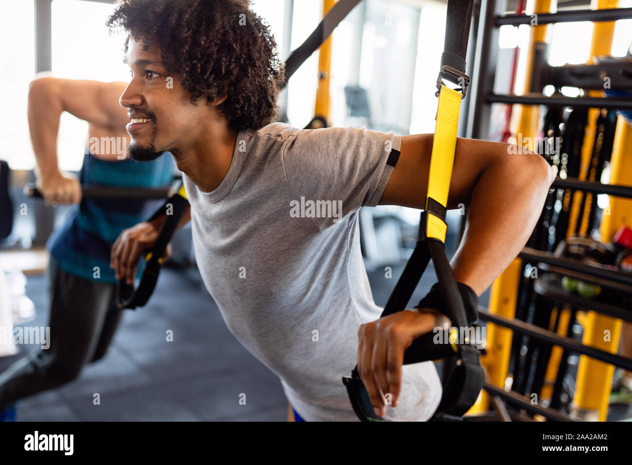 Man training with trx fitness straps in the gym. Workout healthy