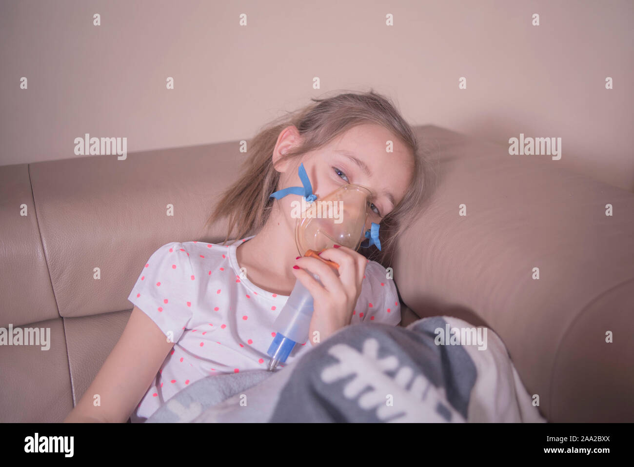 The little girl does inhalation at home.The girl sits with inhalation. The  child is sick and sad. The little girl feels bad Stock Photo - Alamy