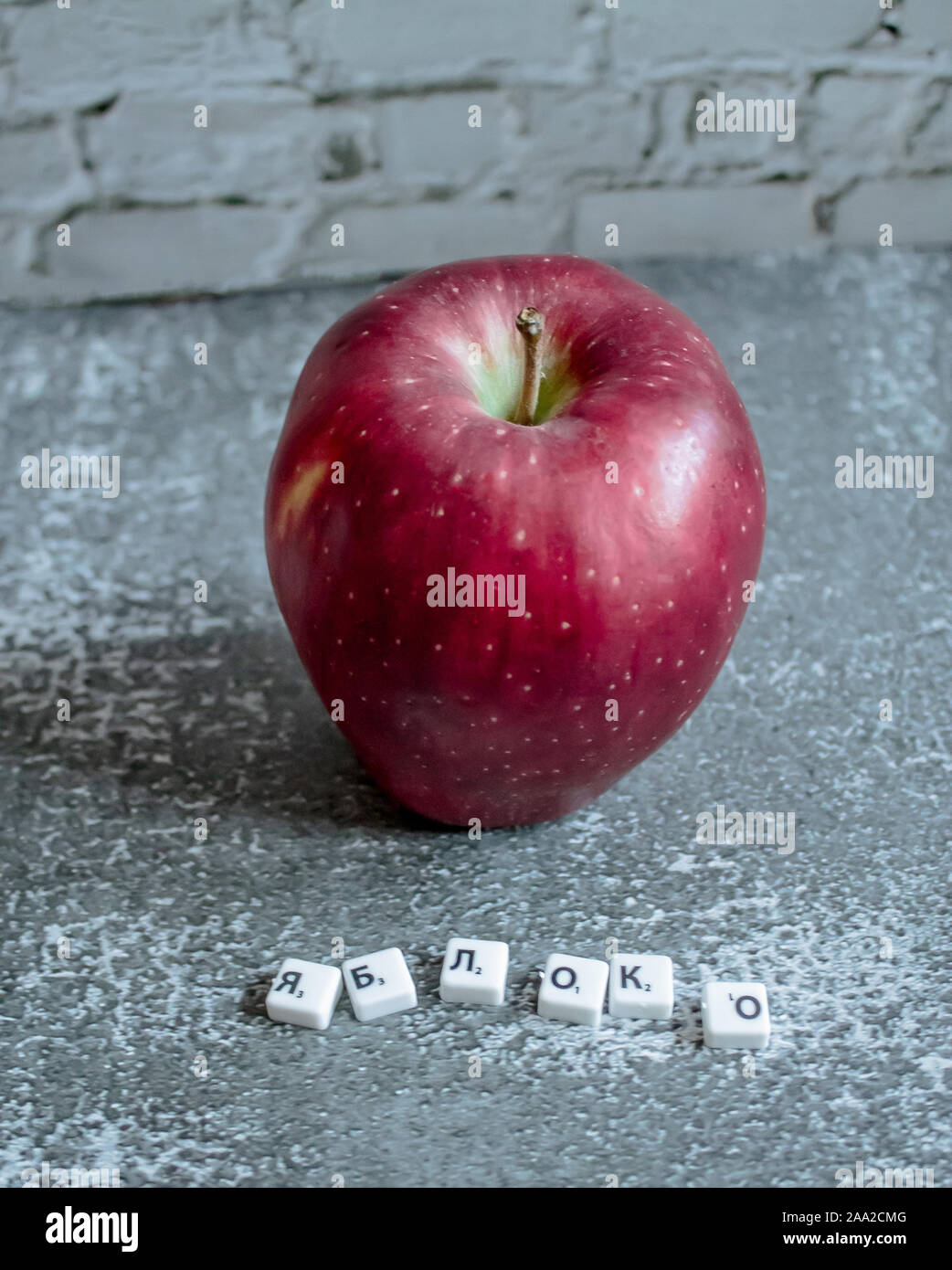 Gray background, red apple top view. The inscription apple in Russian. Stock Photo