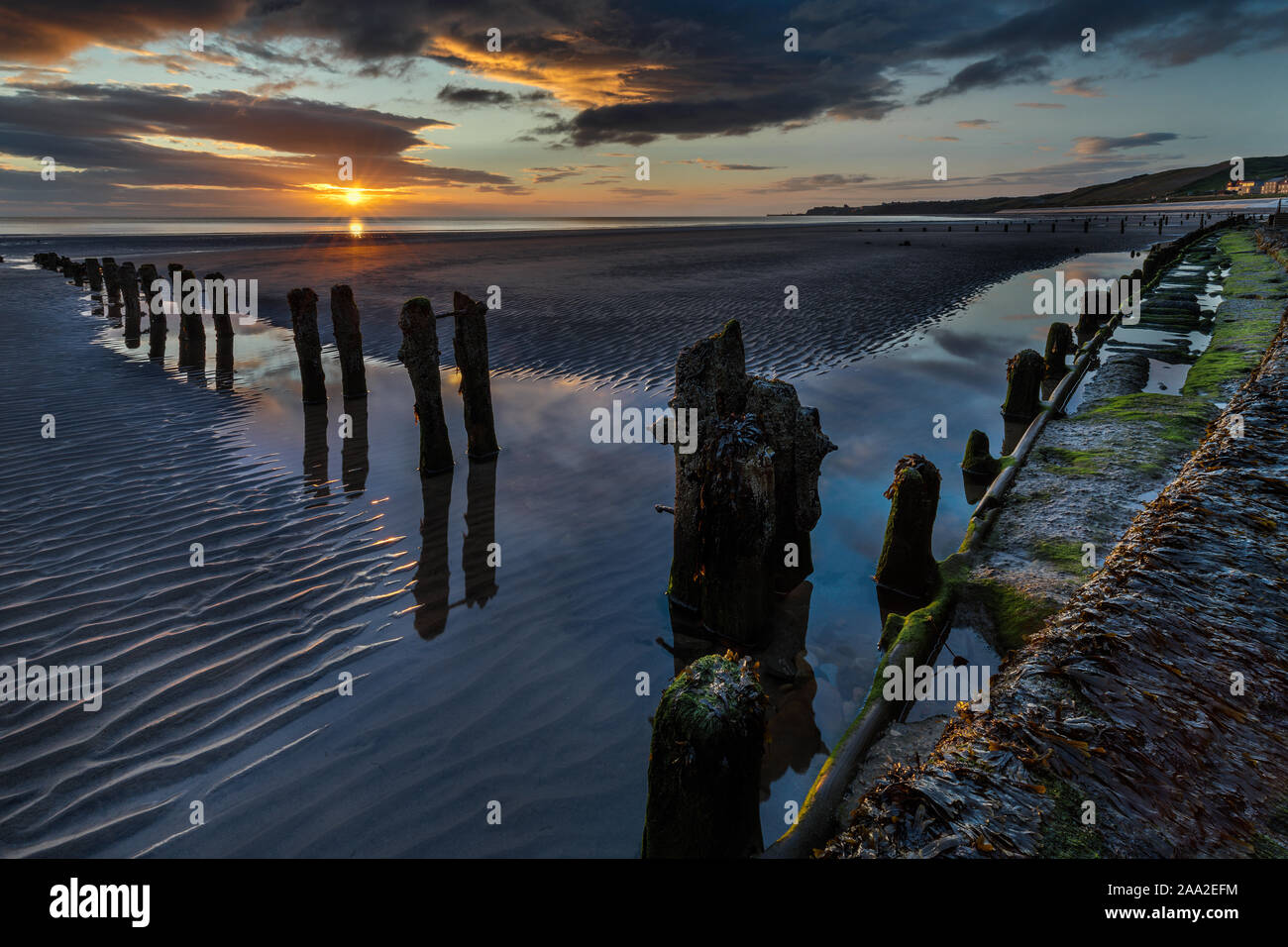 Early morning view, with remains of groynes, on the beach at the seaside village of Sandsend, near Whitby North Yorkshire England UK Stock Photo