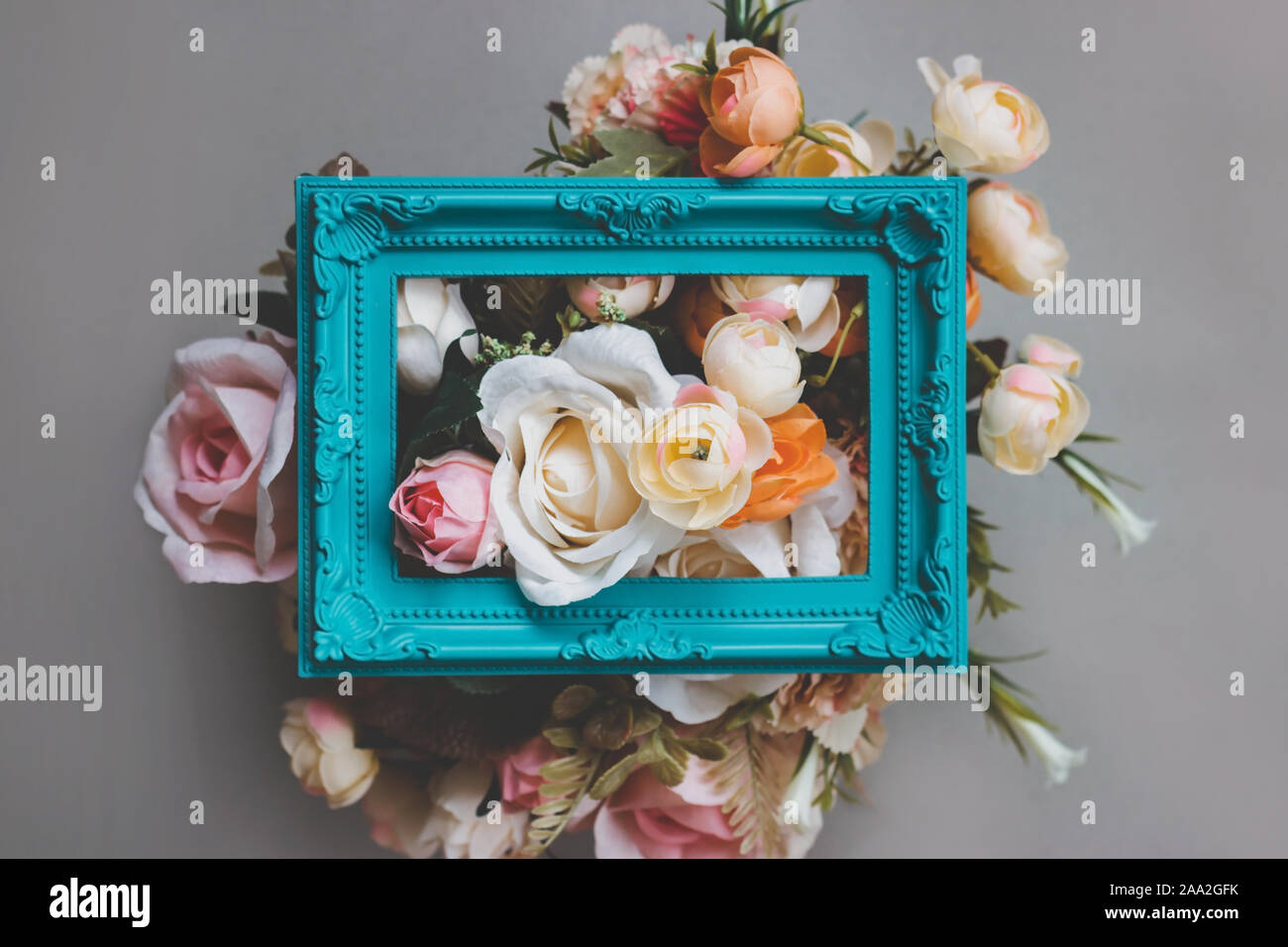 Composition made of photo frame and artificial flowers in pastel colors ...