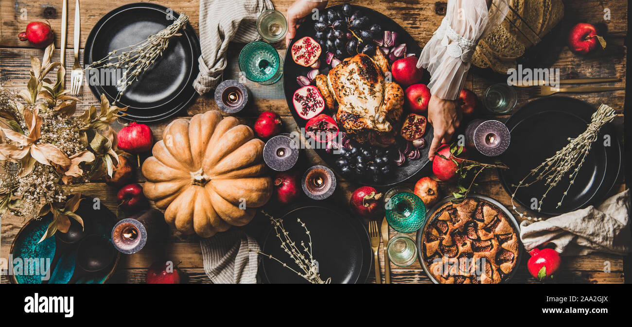 Thanksgiving table setting with roasted chicken and pie, wide composition Stock Photo