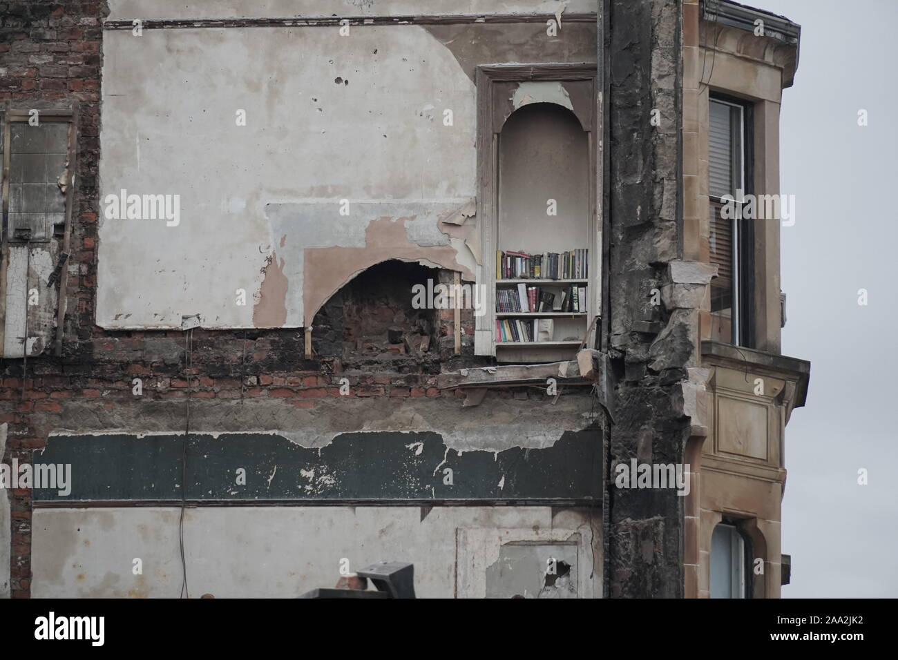 Glasgow, UK. 19th Nov, 2019. Demolition continues following a fire and a collapse of a tenement building in Pollokshields in Glasgow. A single book shelf reminds of once a cosy home, including titles such as Stephen King and Decoder Credit: Pawel Pietraszewski/Alamy Live News Stock Photo