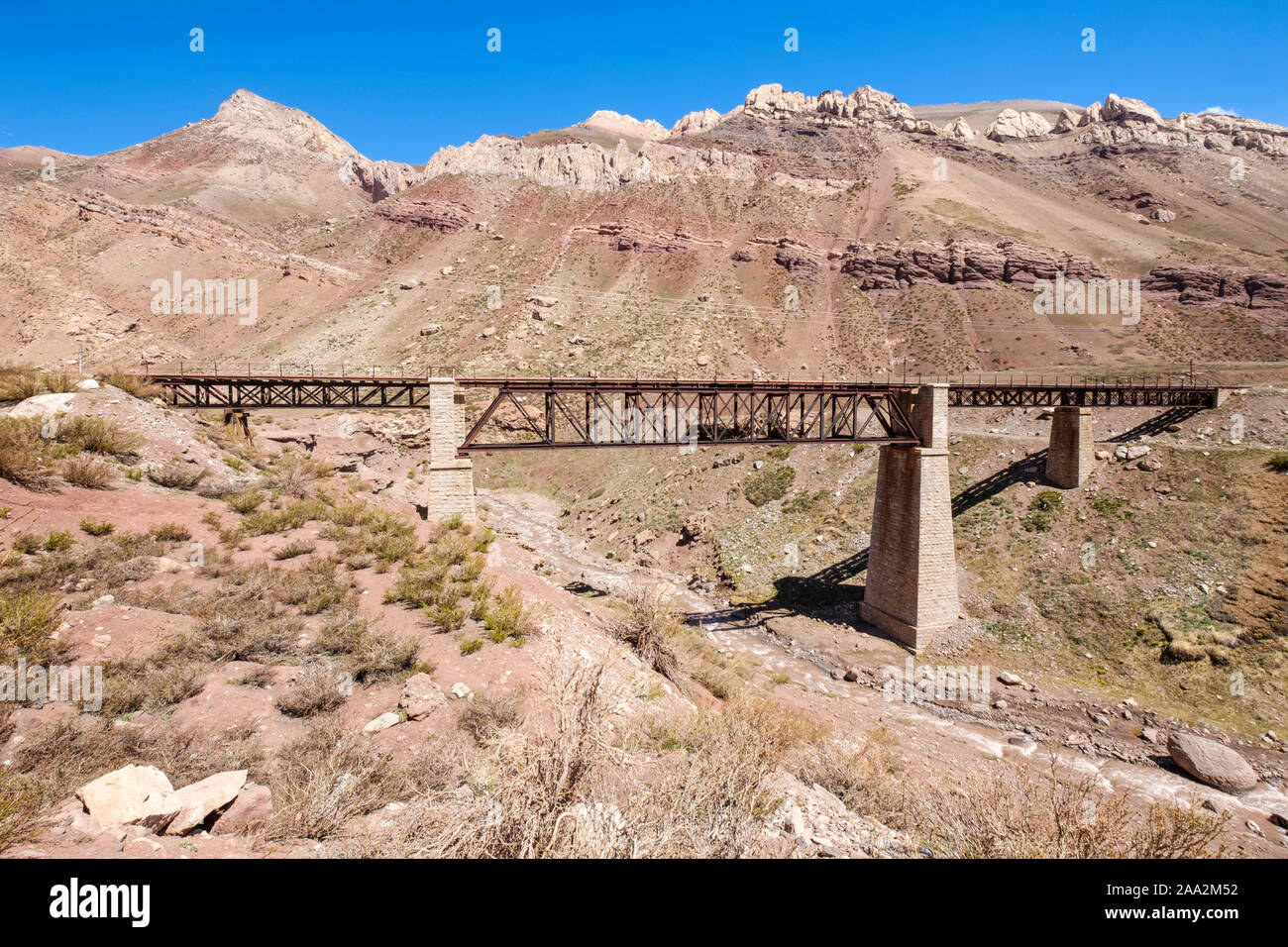 Railway iron bridge over the River Mendoza on the Andean Mountain Range near Puente del Inca in Mendoza Province, Argentina Stock Photo