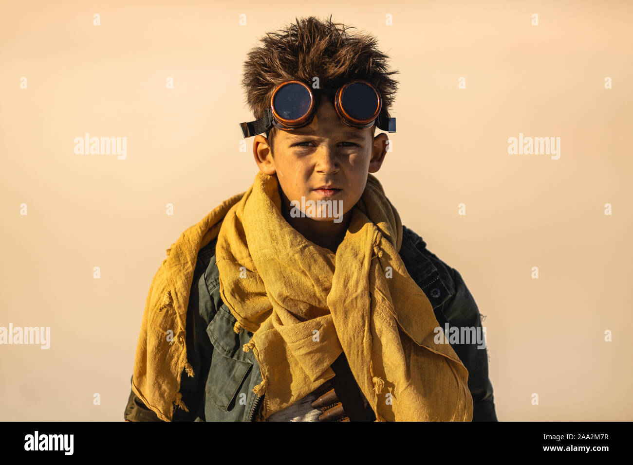 Post-apocalyptic boy outdoors in the desert. Nuclear post-apocalypse. Life after doomsday concept. Desert and dead wasteland on the background. Stock Photo