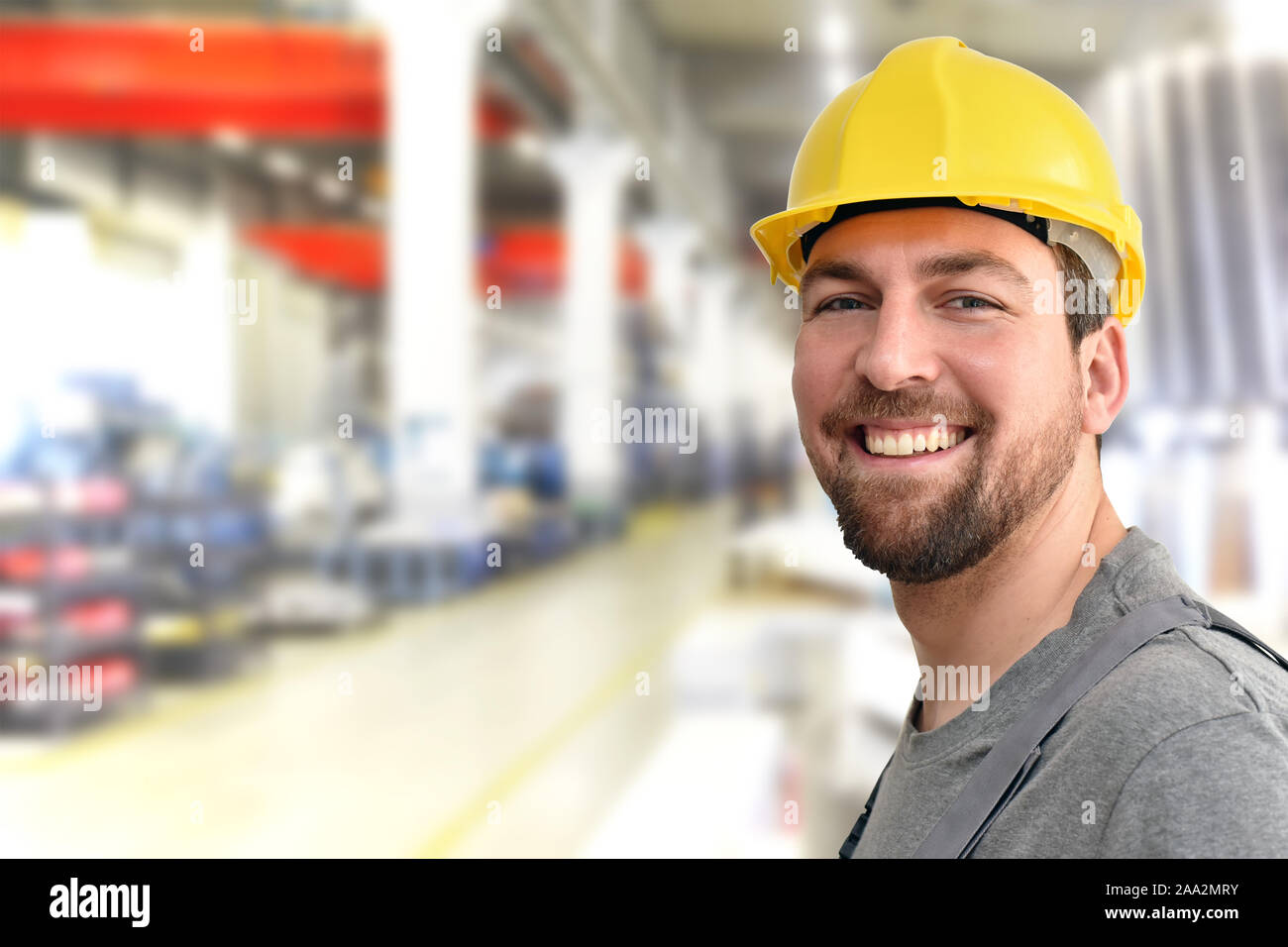 cheerful industrial worker in a factory in work clothes to repair machines and equipment Stock Photo