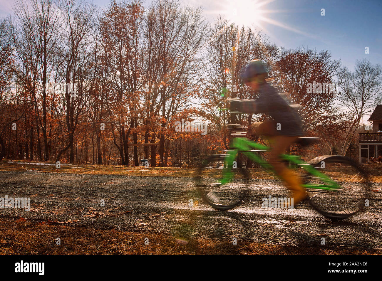 Boy riding a bicycle outside his house, USA Stock Photo