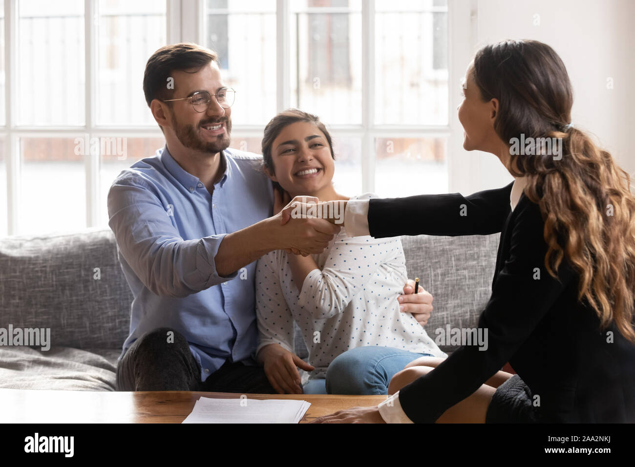Young spouse shaking hands with professional financial consultant. Stock Photo