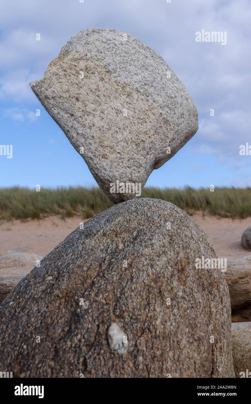 Stone balancing on stone - stone laid on other stone on seacoast Stock Photo