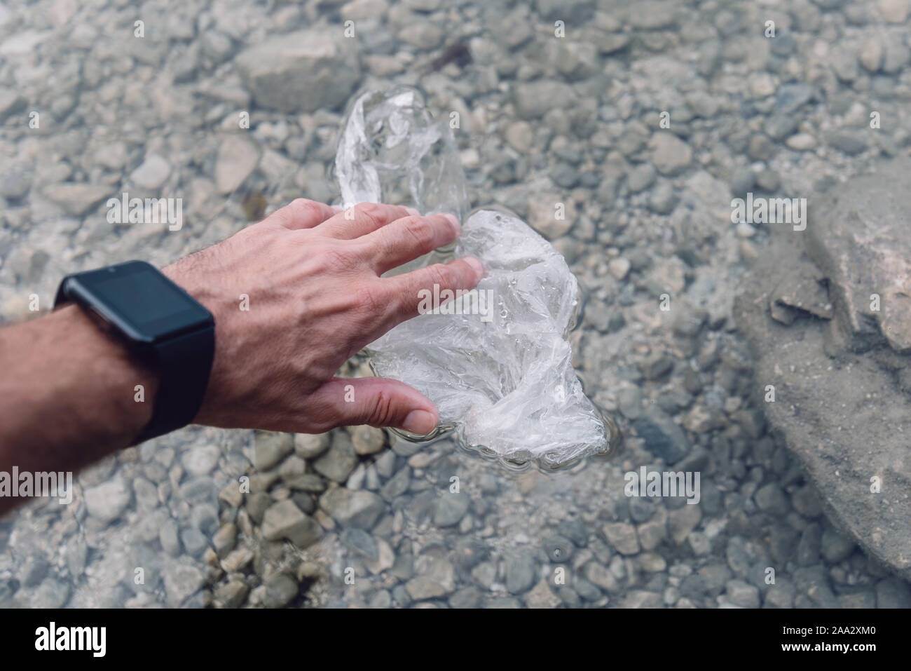 Environmentalist taking plastic bag from water, close up of hand Stock Photo