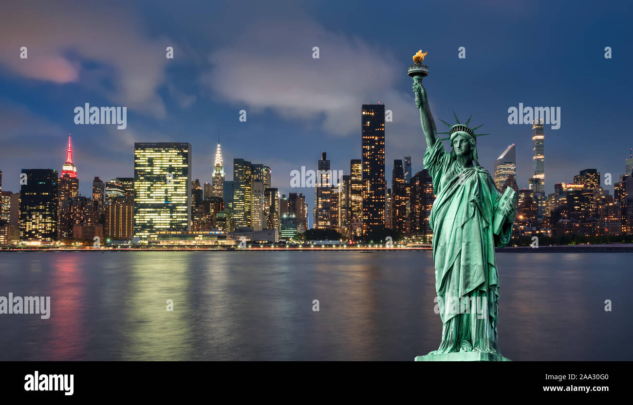Statue of liberty in front of Manhattan skyline, at night, during blue hour Stock Photo
