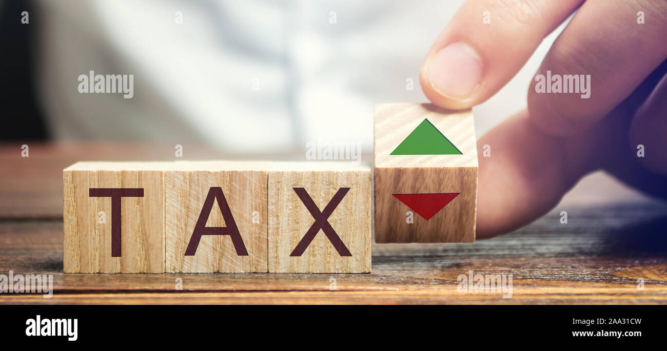 Wooden blocks with the word Tax and up and down arrows. Business and finance concept. Taxes and taxation. The tax burden Stock Photo