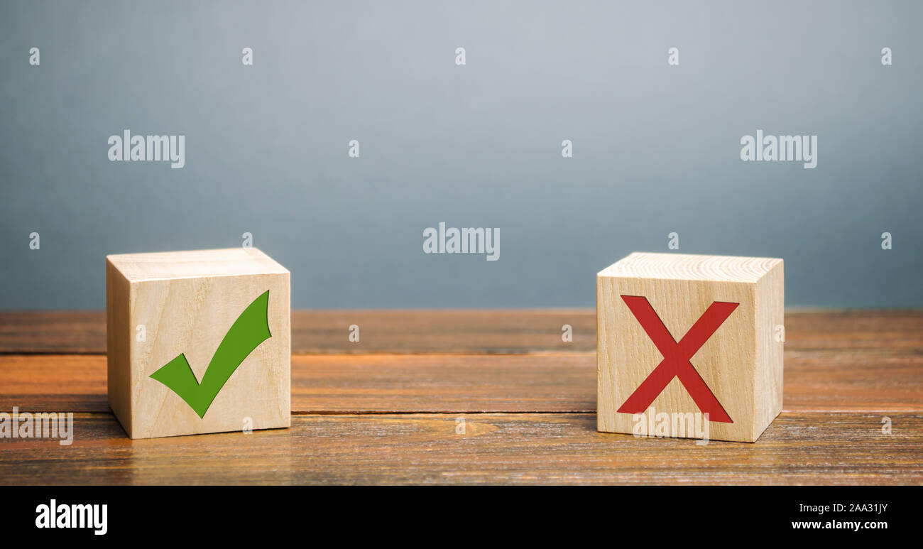 Wooden blocks with a green check mark and red X. The concept of choice and making the right decision. Business management. Stock Photo
