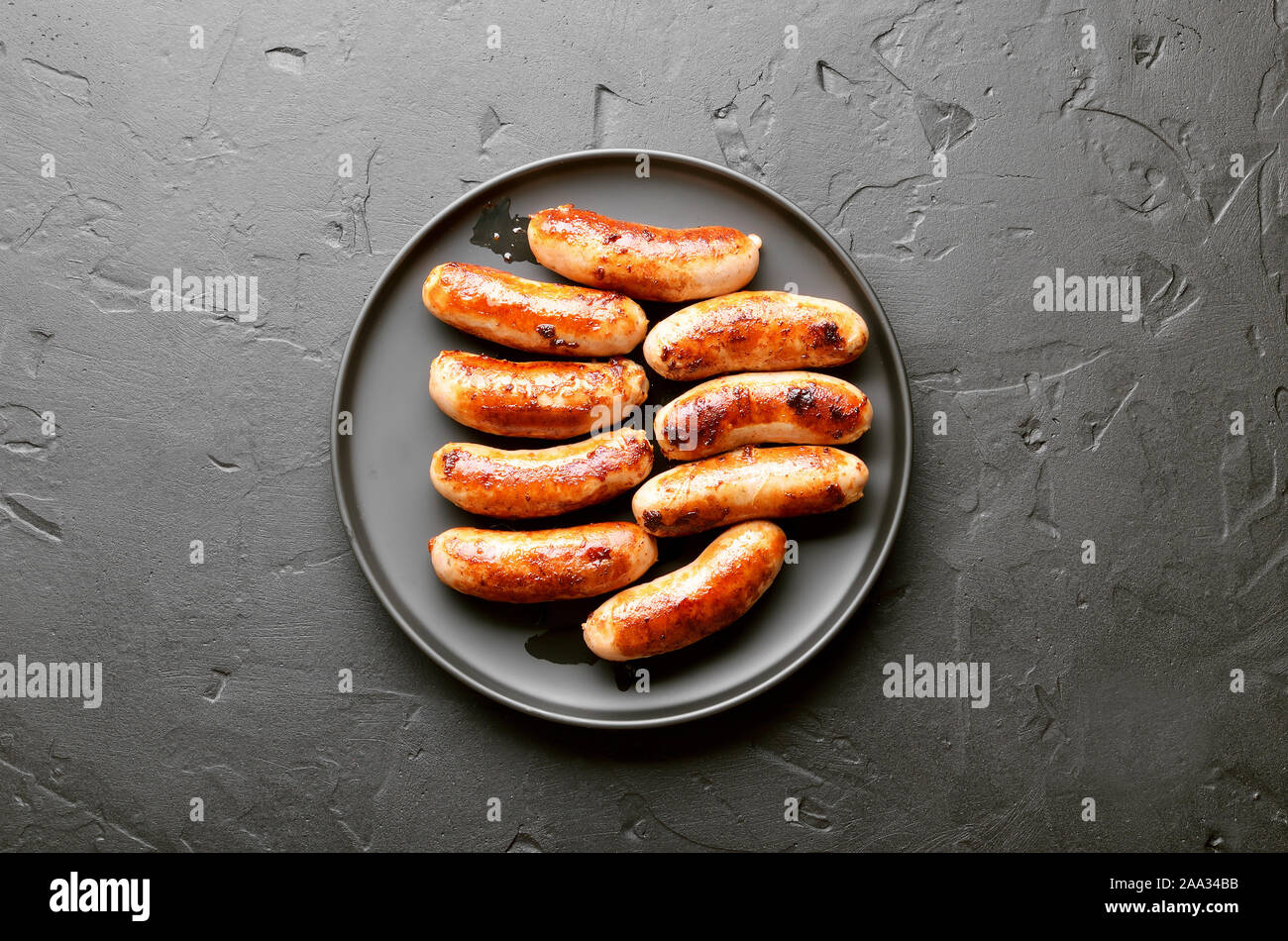 Fried sausage on over black stone background. Top view, flat lay Stock Photo