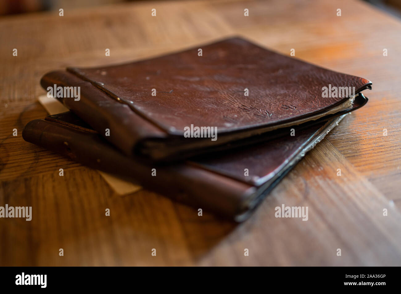 Leather menu on a wooden chevy chic table in a retro restaurant bar Stock Photo