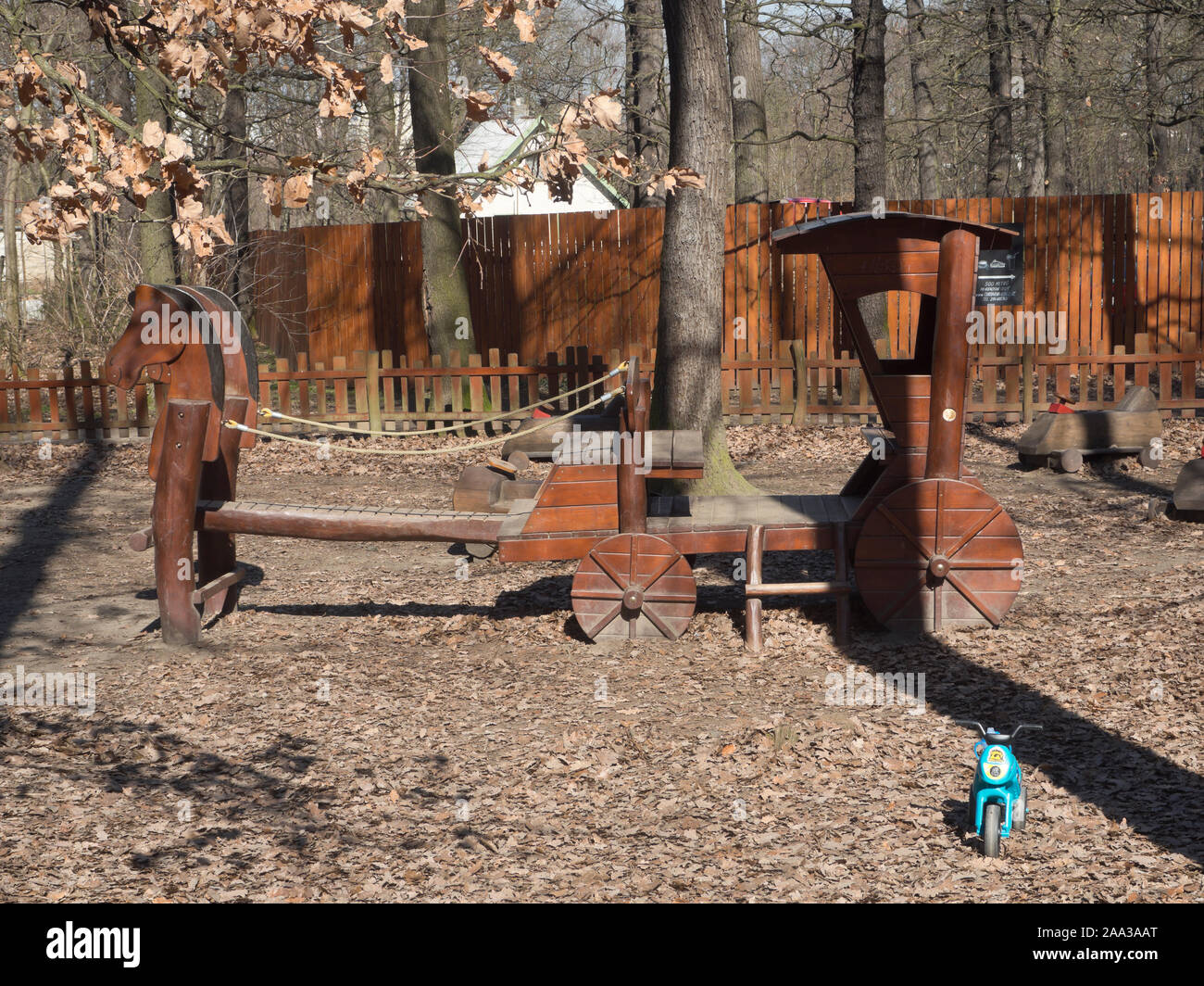 Sturdy wooden horse and cart with a contrasting plastic roller toy in a playground in the Čimický háj forest in a suburb of Prague Czech Republic Stock Photo