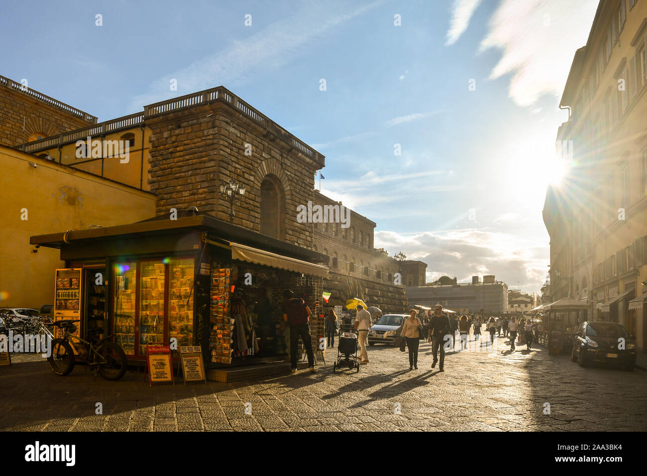 Backlight view of the historic centre of Florence, Unesco World Heritage Site, with a newsstand in front of Palazzo Pitti museum, Tuscany, Italy Stock Photo