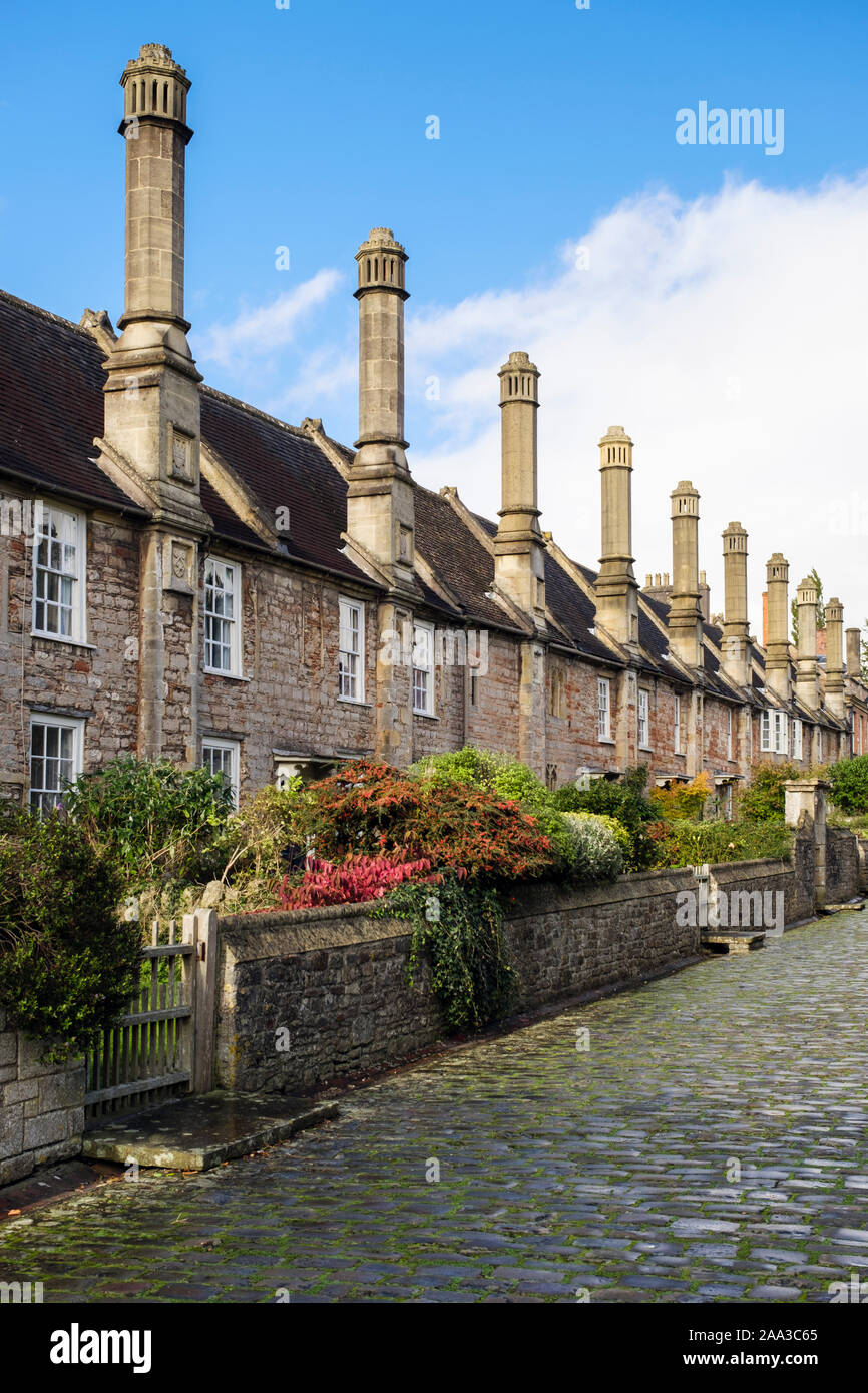 Row of 14th century terraced houses with tall chimneys on cobbled