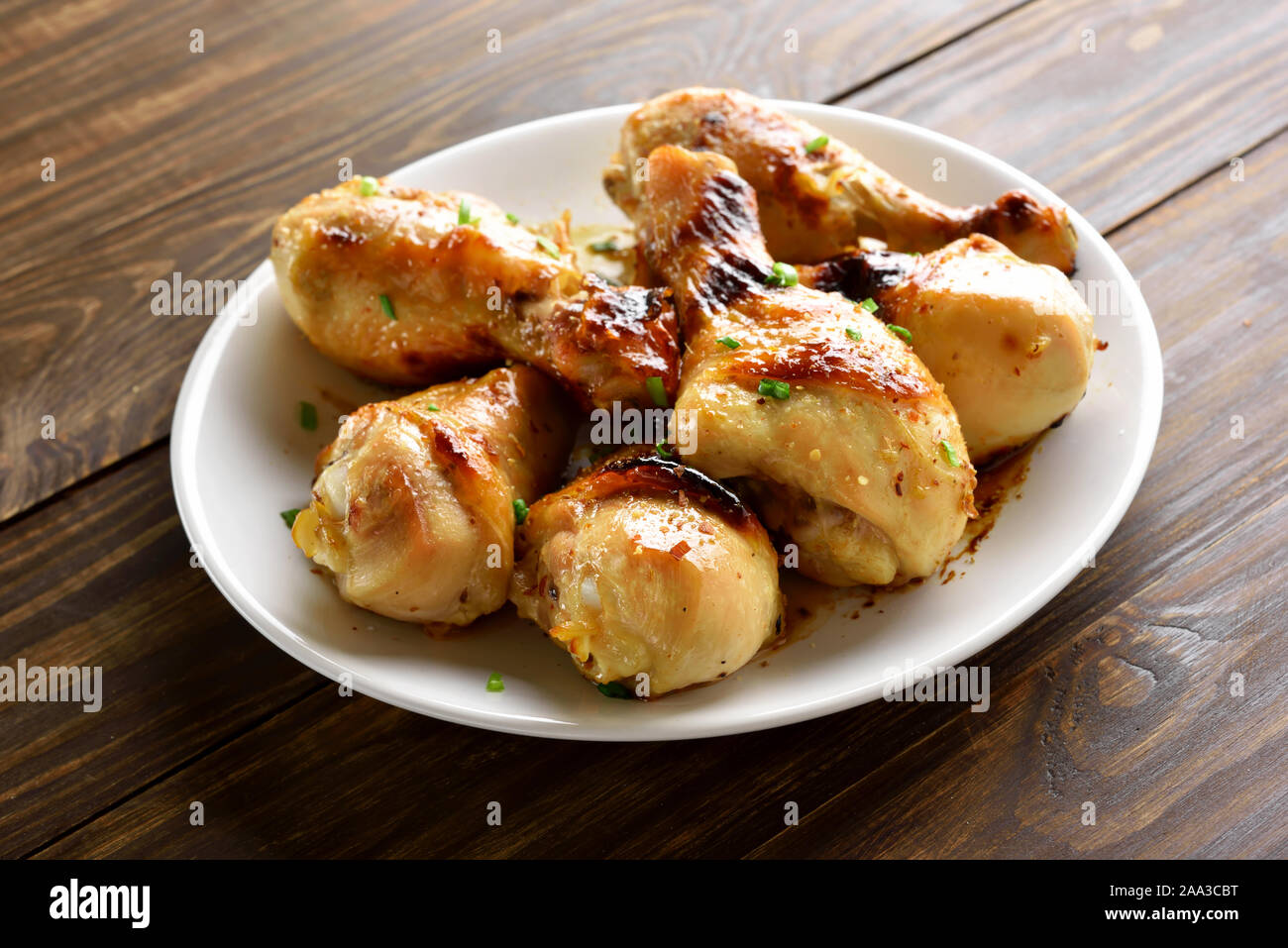 Fried chicken drumsticks on white plate, close up view Stock Photo