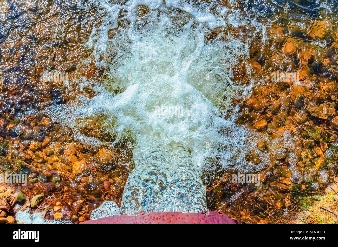 Water flowing out of a metal storm/drainage pipe. Stock Photo