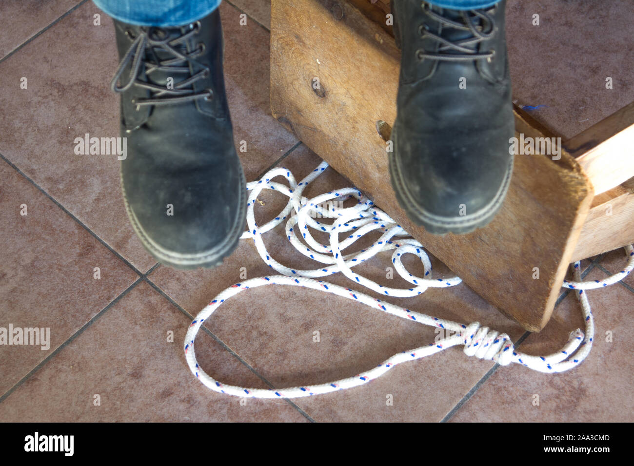 feet of a hanged dead man dangling with the stool and the rope used to hang  himself Stock Photo - Alamy