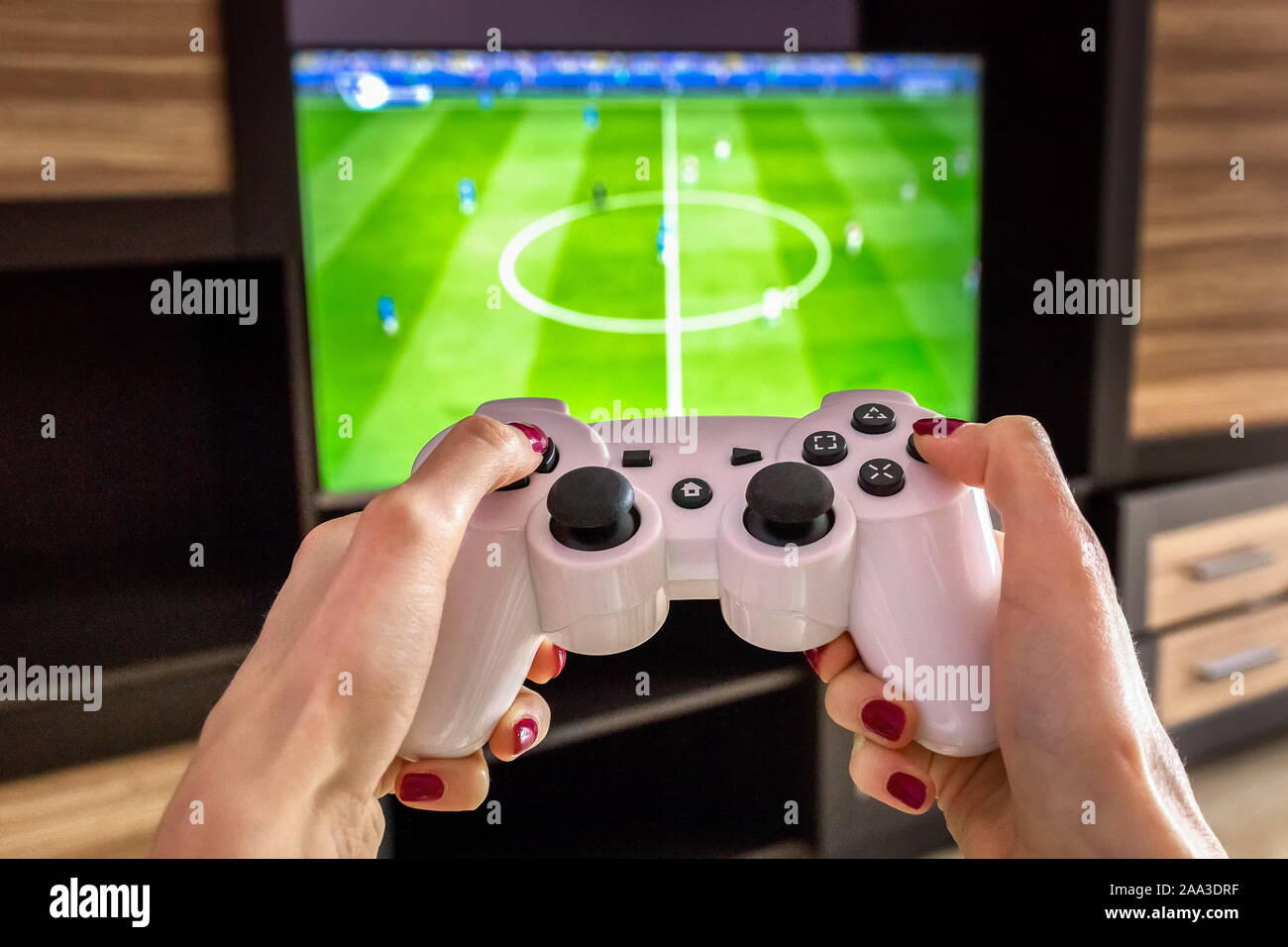 modul Mission Mentor White gaming joystick, gamepad, standard controller is aimed at the TV, Pc  games is on the screen, control fifa football game ps4, xbox Stock Photo -  Alamy