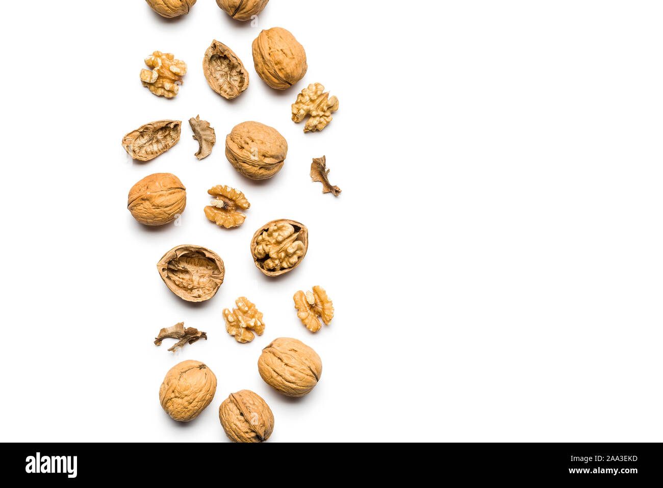 top view of walnuts closed and broken scattered on a white background with copy space Stock Photo