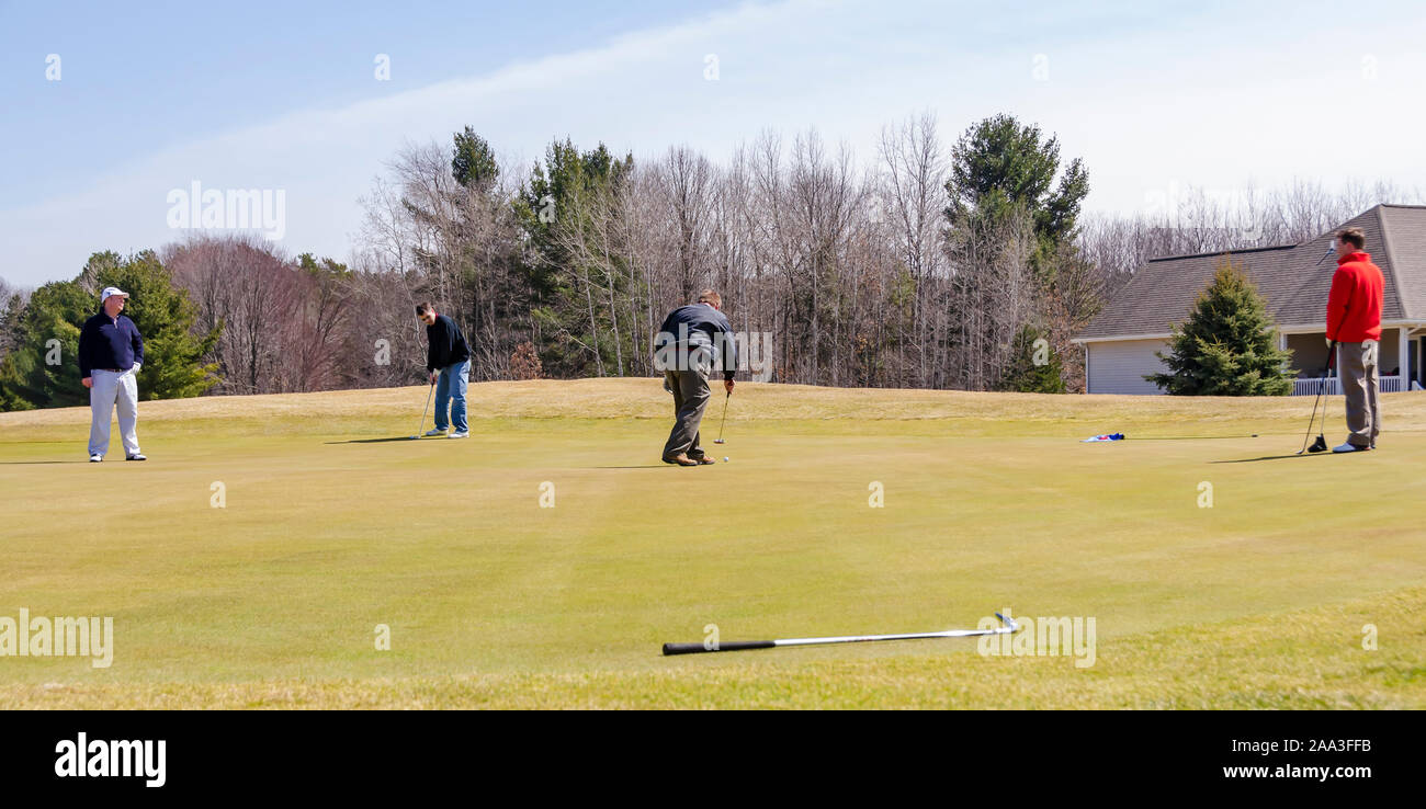 A golfer putting on a green of the golf course. Stock Photo