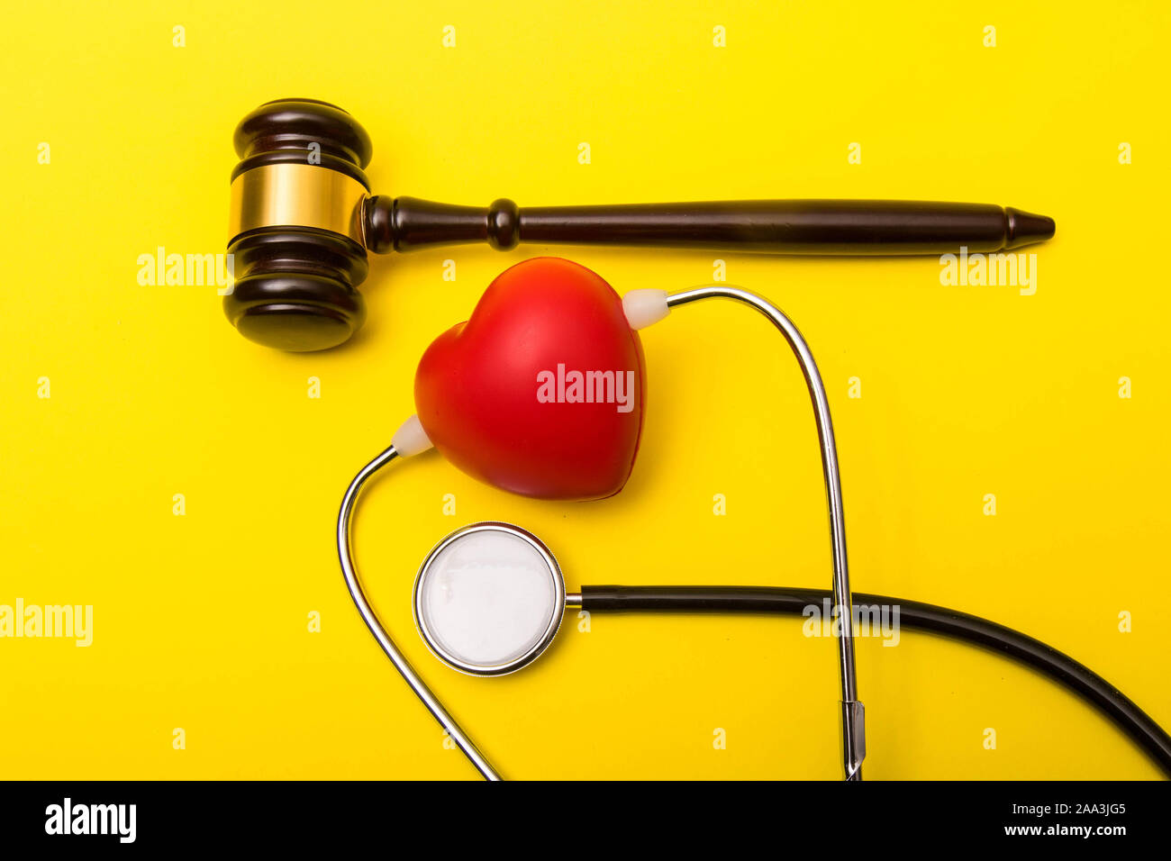 Medical malpractice lawsuit concept showing a gavel on a yellow background Stock Photo