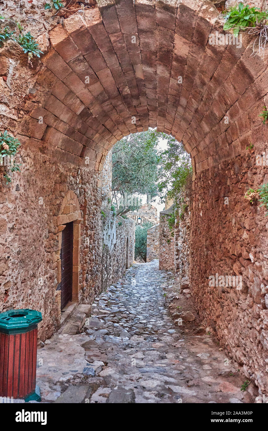 Stone alley into the picturesque castle town of Monemvasia during winter. Architectural stone buildings and beautiful narrow paved streets. Stock Photo