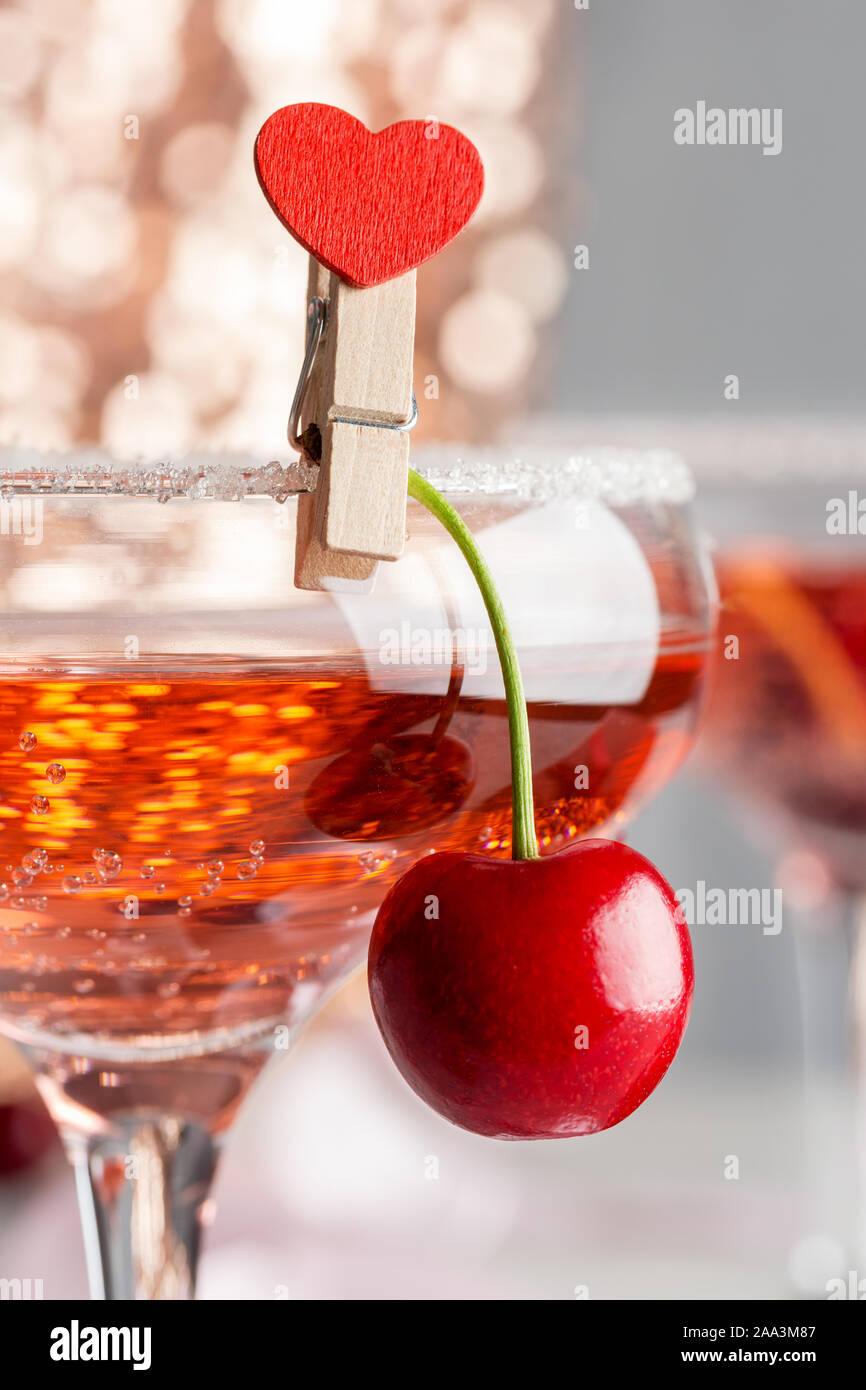 sweet cherry in glass with champagne heart pin. Concept of food styling beverage Stock Photo