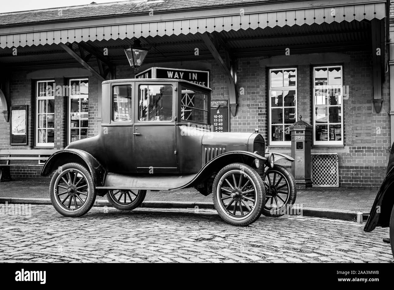 Black and white, side view close up of isolated vintage car: 1920s Ford Model T, parked outside vintage train station, Severn Valley heritage railway. Stock Photo