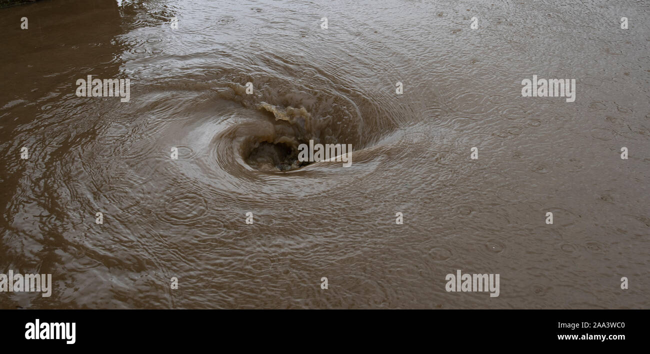 Water going down aroad drain after a thunderstorn, creating a whirlpool
