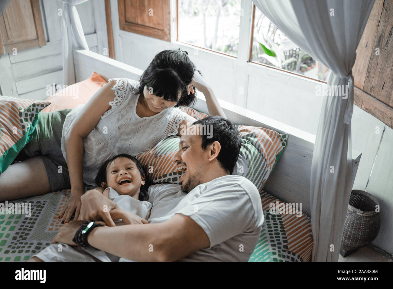 Happy family playing together on the bed Stock Photo