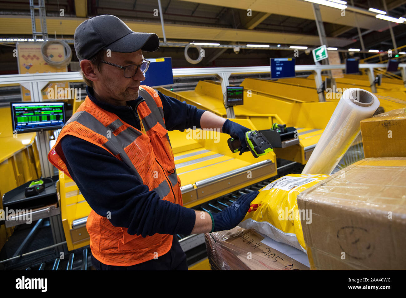 Cologne, Germany. 19th Nov, 2019. A DHL employee scans a parcel at the  company's new express hub at Cologne/Bonn Airport. Deutsche Post DHL has  put a new hub for its express shipments