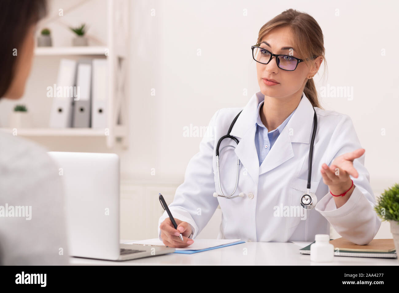 Talking doctor patient desk hi-res stock photography and images - Alamy