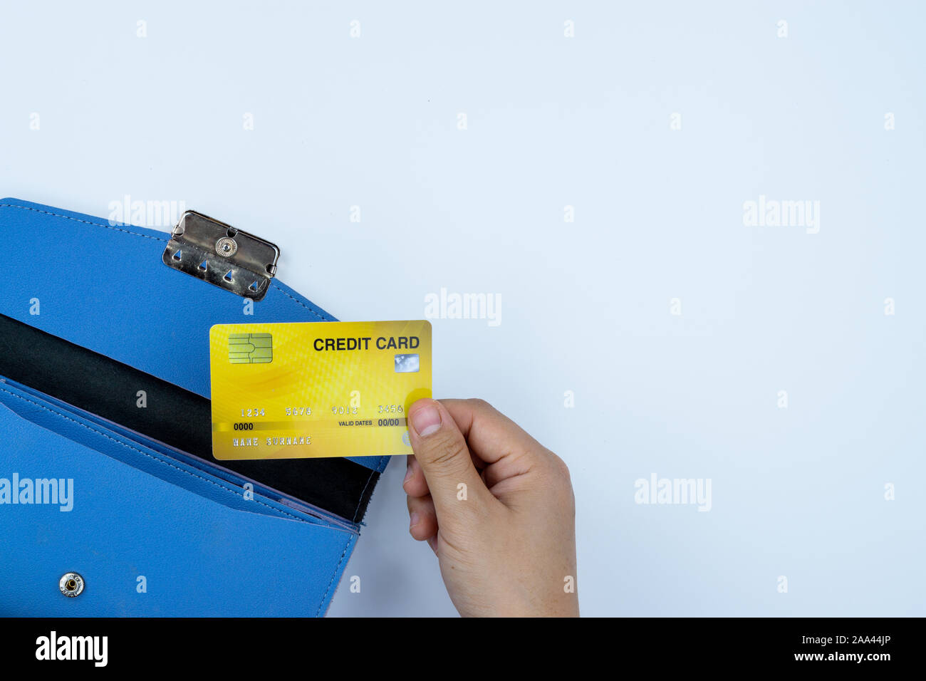 Woman hand taking out the credit card from blue purse for payment on the white background. Finance and money concept, top view, copy space for text. Stock Photo