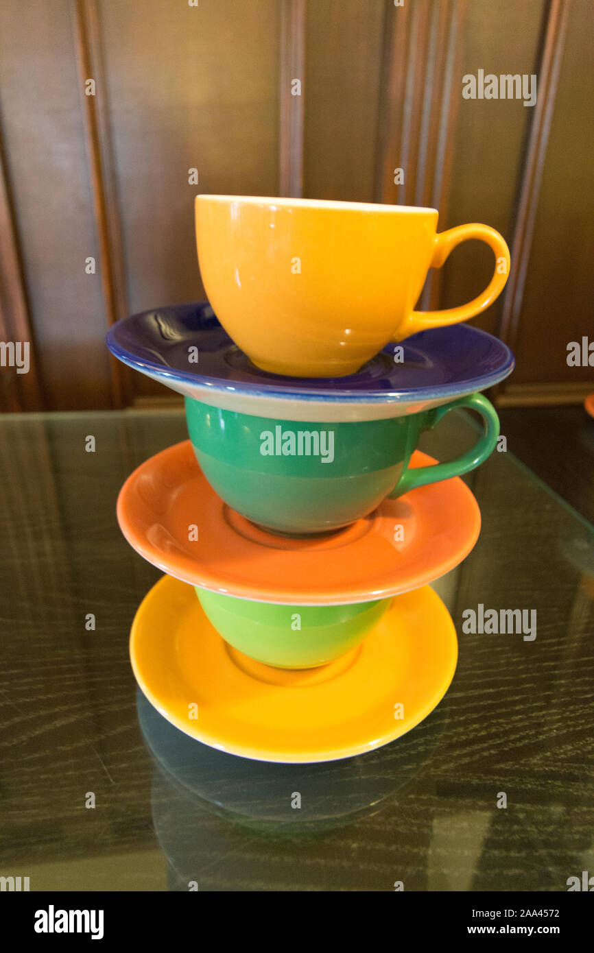 Brightly coloured cups and saucers, stacked in piles ready for use Stock Photo Alamy