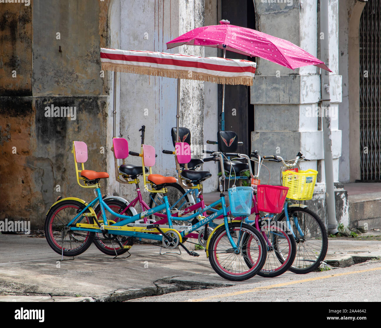 PENANG, MALAYSIA, NOV 12 2017, Colorful bicycles with umbrellas for tourists parked on the city street. Stock Photo