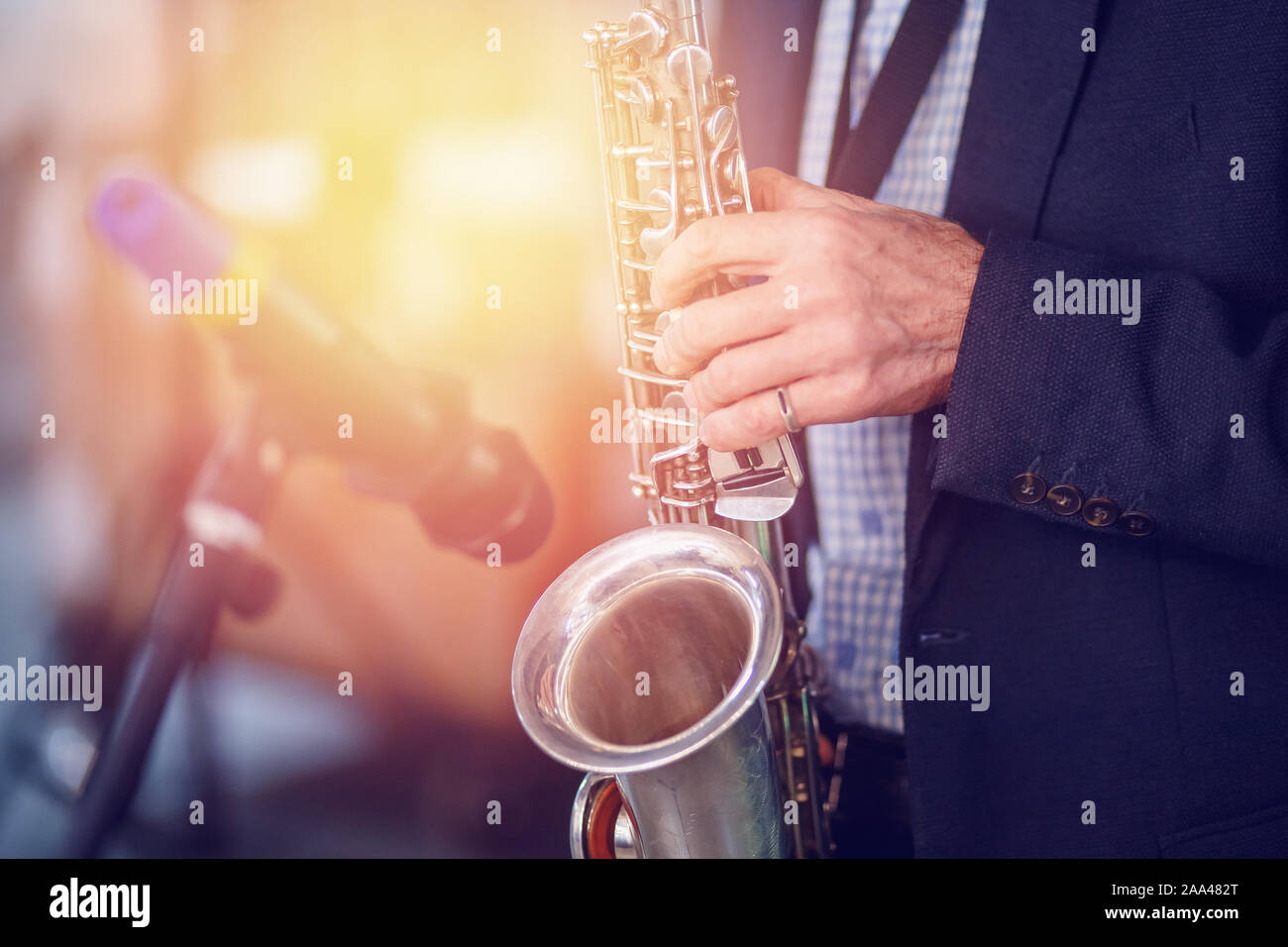 Jazz man musician playing saxophone with sun light. Stock Photo