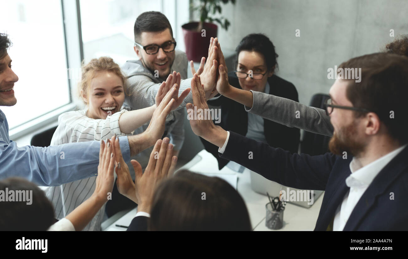 Motivated business team giving group high five Stock Photo - Alamy