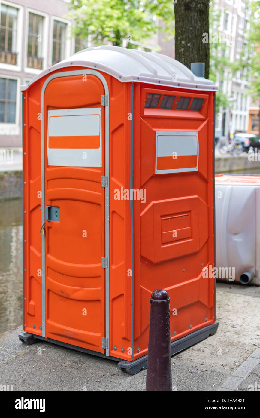 One Orange Portable Toilet Cabin at Street Stock Photo