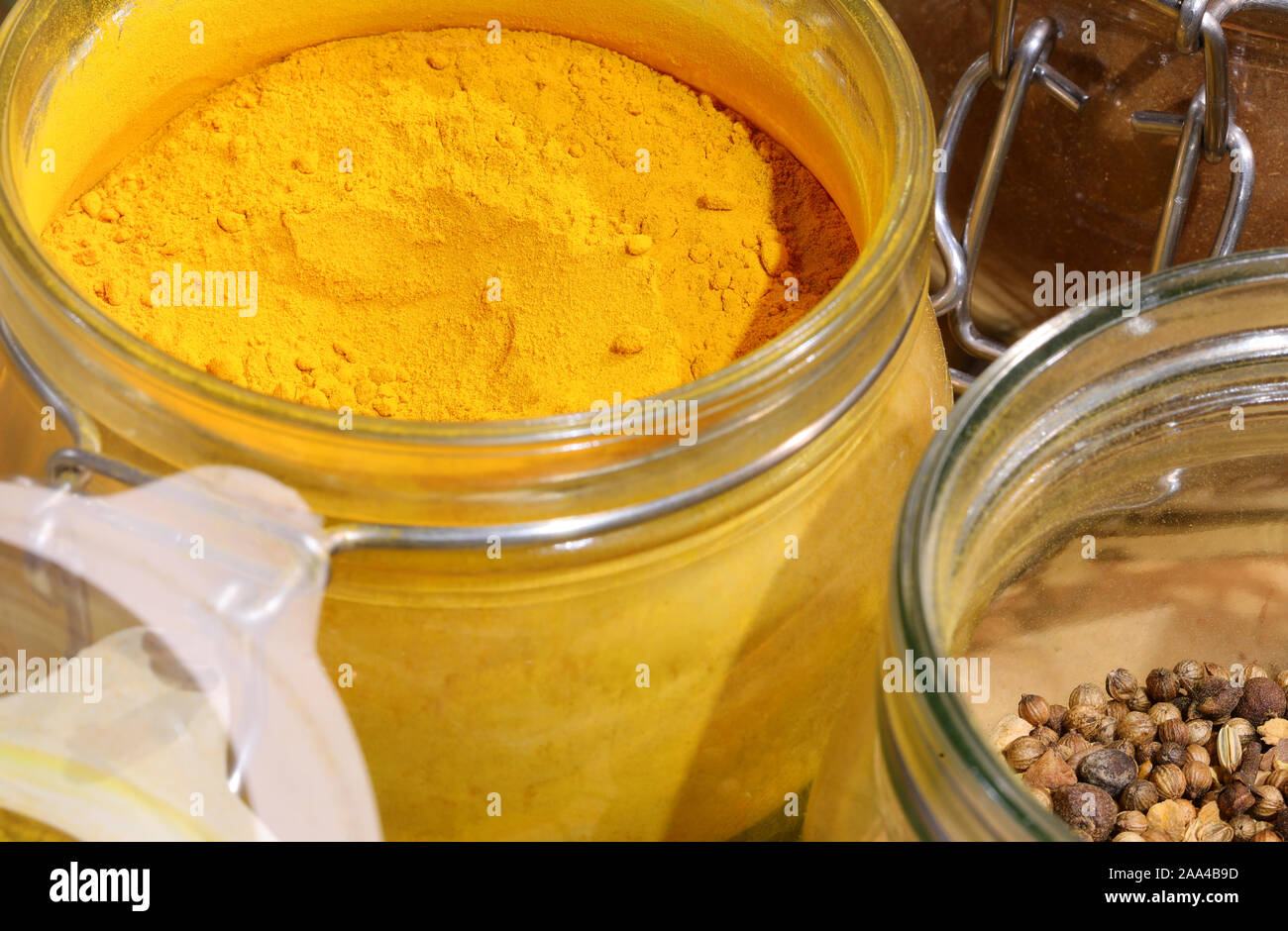 yellow curry powder and peppercorns in the glass jar Stock Photo