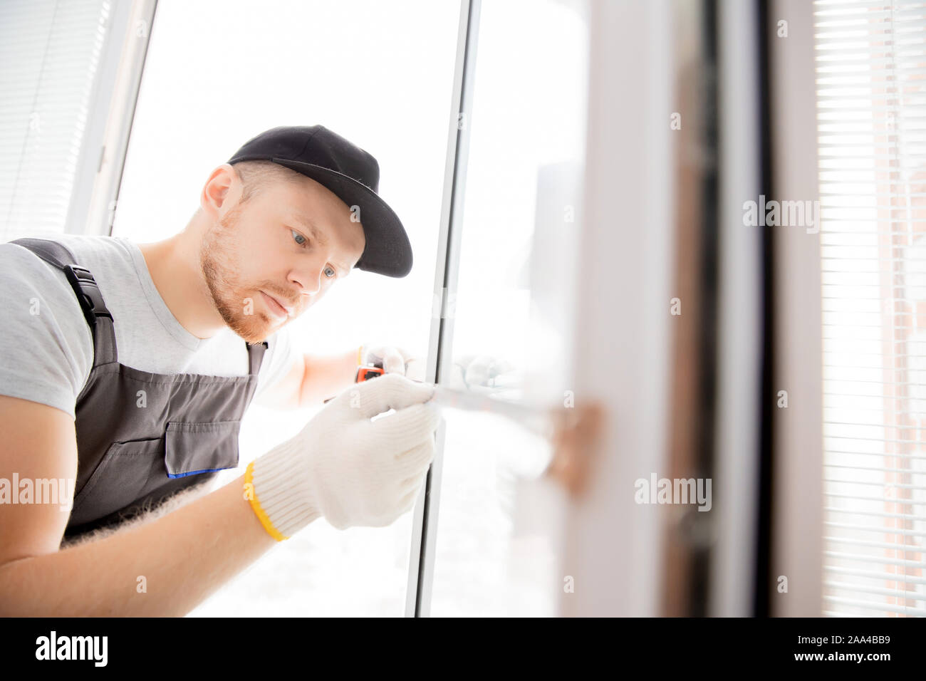 Master worker measures upvc window with ruler, installation process. Stock Photo