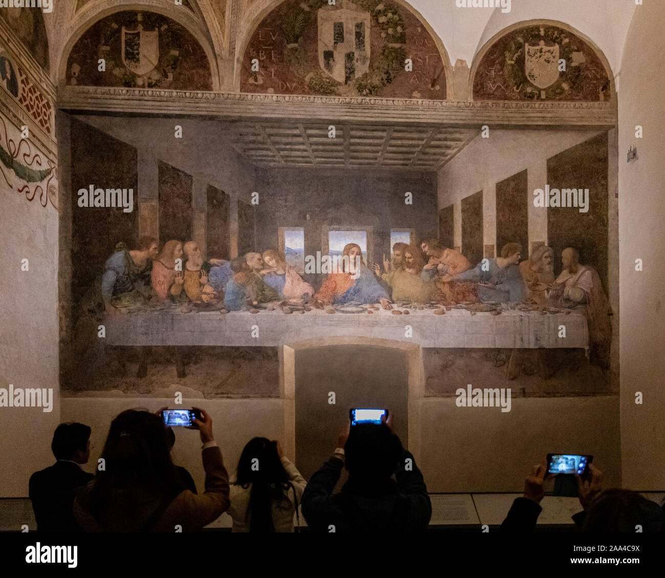 Milan, Italy - Nov 6, 2019: Smartphone addicted tourists taking photos while visiting the Last Supper mural painting by Leonardo da Vinci in the refec Stock Photo