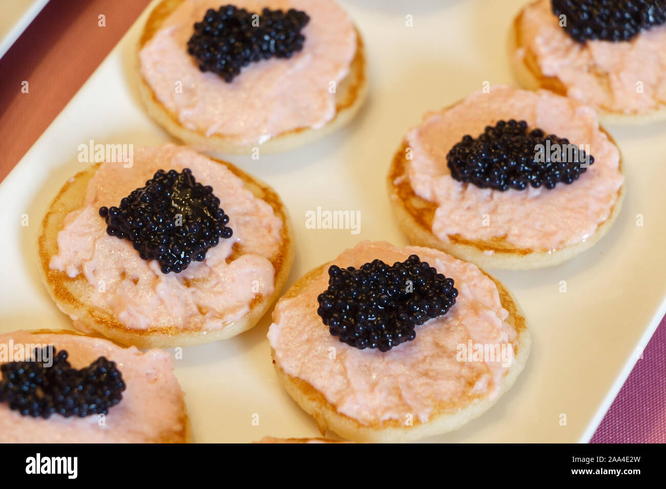 Blinis with taramasalata and black lump-fish roe on a dish Stock Photo
