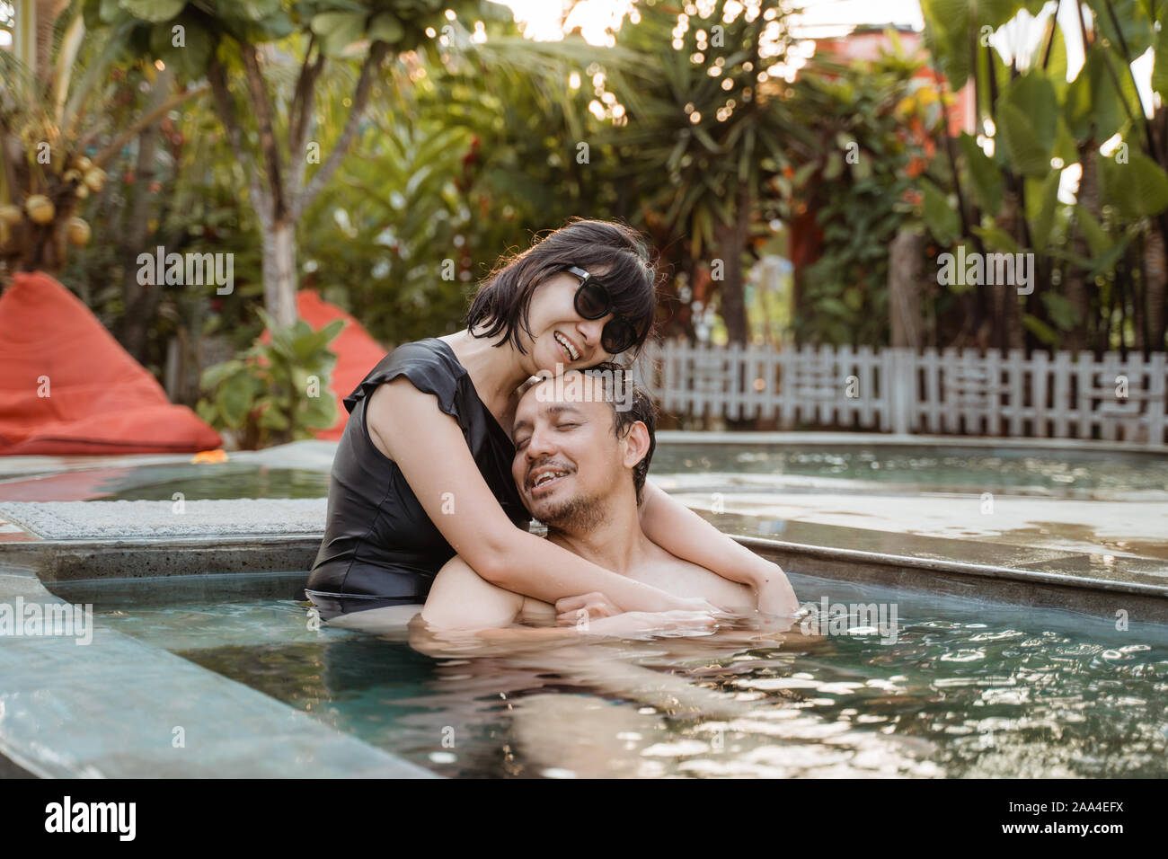 Happy couple hugging in a swimming pool Stock Photo